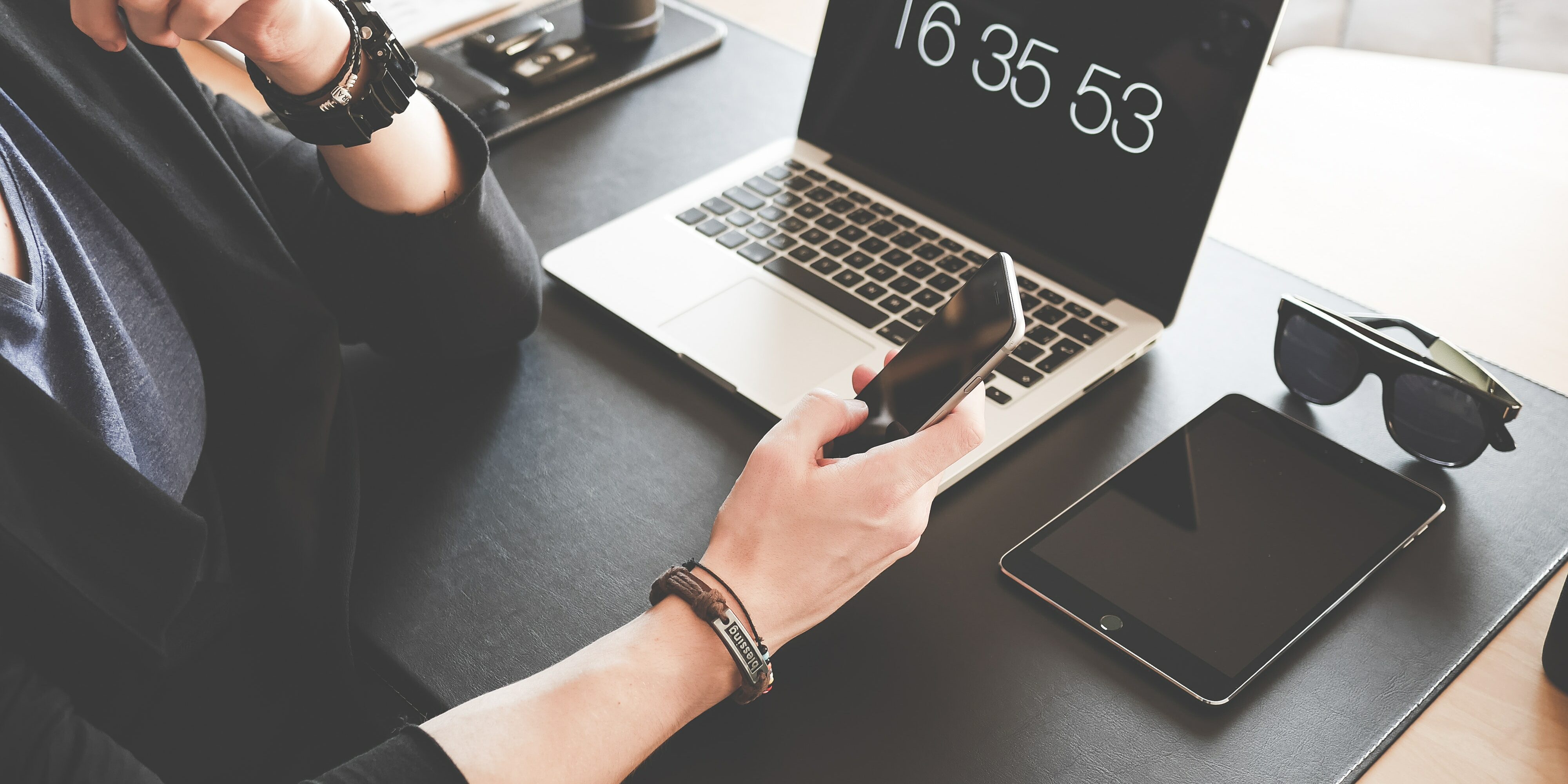 woman-using-a-smartphone-while-fronting-a-macbook-pro-and-196656