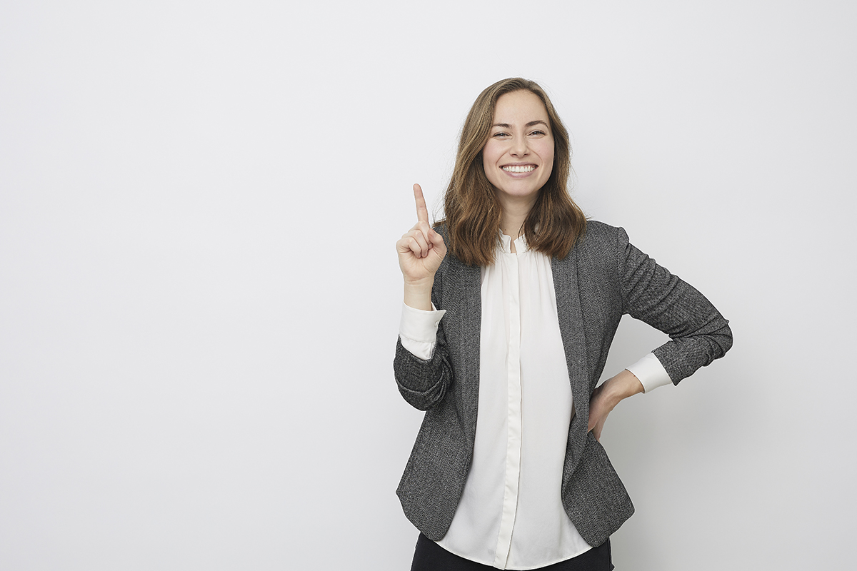 Businesswoman is pointing up while looking